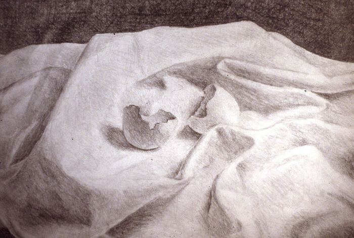 Pencil still life of a cracked eggshell on draped cloth