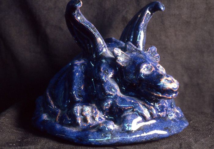 Blue-glazed ceramic sculpture of a reclining winged dragon